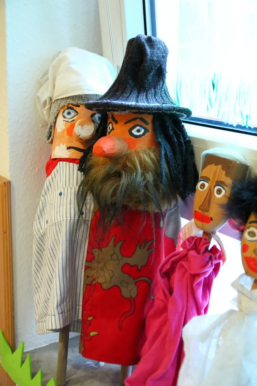 Nahaufnahme der Stabpuppen, vorn eine Figur mit Hut, Bart und rotem Umhang.
