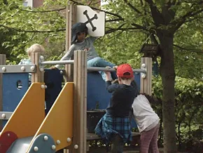 Kinder klettern auf einem Klettergerüst im Außengelände.