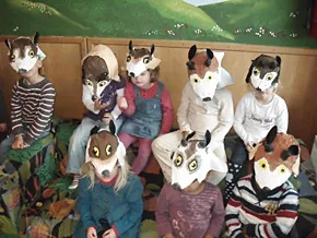 Eine Gruppe Kinder trägt selbst gebastelte Wolfsmasken.